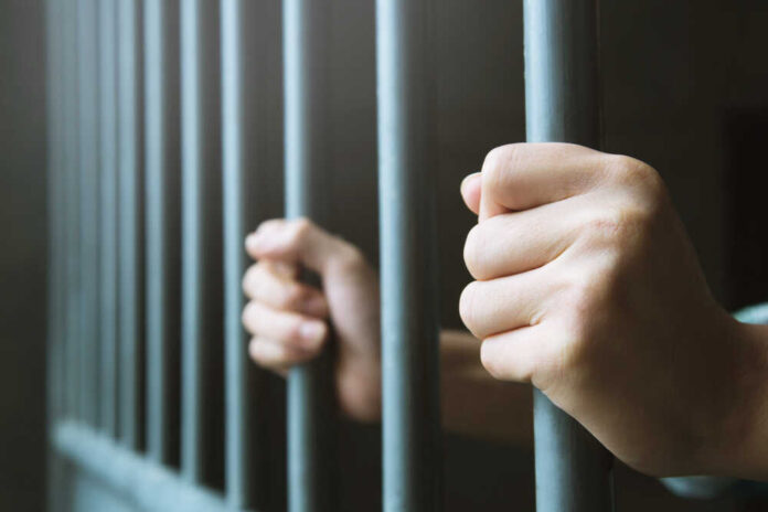 Man,In,Prison,Hands,Of,Behind,Hold,Steel,Cage,Jail