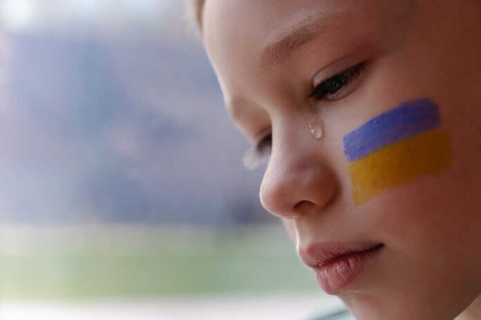 A,Child,With,The,Flag,Of,Ukraine,Is,Crying.,Sadness
