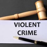 Gavel and pen near "Violent Crime" sign.