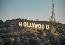 Billionaire Exodus: Spielberg Abandons Golden State Hollywood sign with communication tower on hillside.