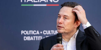 Man in suit holding microphone at event indoors