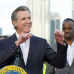 Man speaking passionately at outdoor event with audience