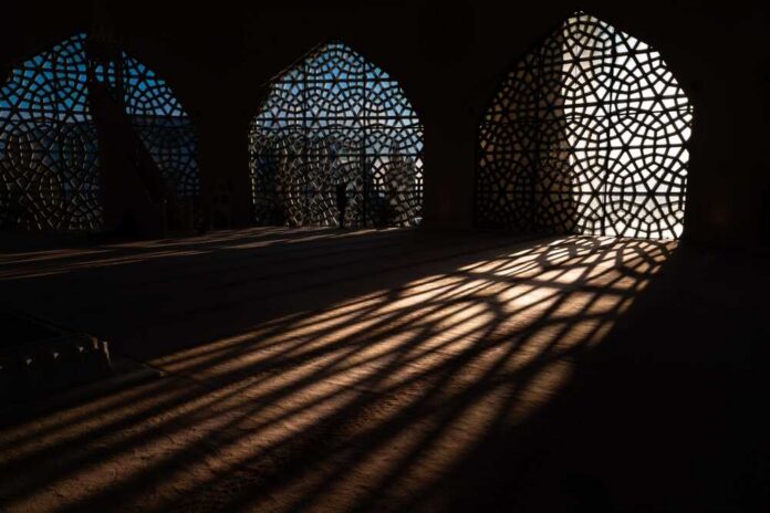 Interior view showcasing intricate geometric patterns and shadows cast by windows
