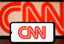 CNN logo on phone and screen background.