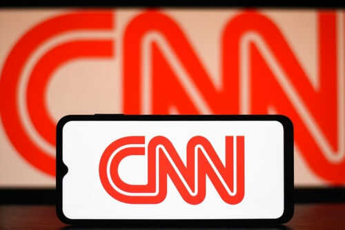 CNN logo on phone and screen background.