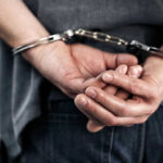Person handcuffed with hands behind back.