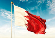 Flag of Bahrain waving against a blue sky
