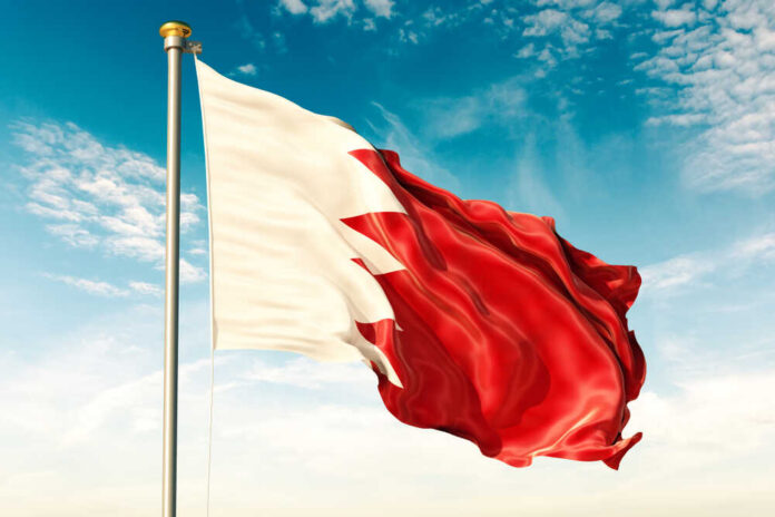 Flag of Bahrain waving against a blue sky
