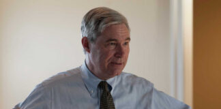 A business professional in a light blue shirt and tie, engaged in conversation