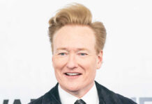 Smiling man in formal attire at a media event