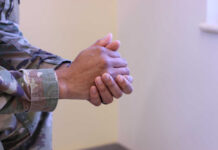 Chaplains’ Divine Role Elevated – Military Shake-Up Close-up of a soldier's hands clasped together in a thoughtful pose