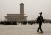 A military guard walking past a crowd at Tiananmen Square in foggy conditions