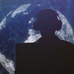 Silhouette of a person wearing headphones in front of a digital globe