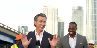 California governor speaking at a construction site with smiling attendees