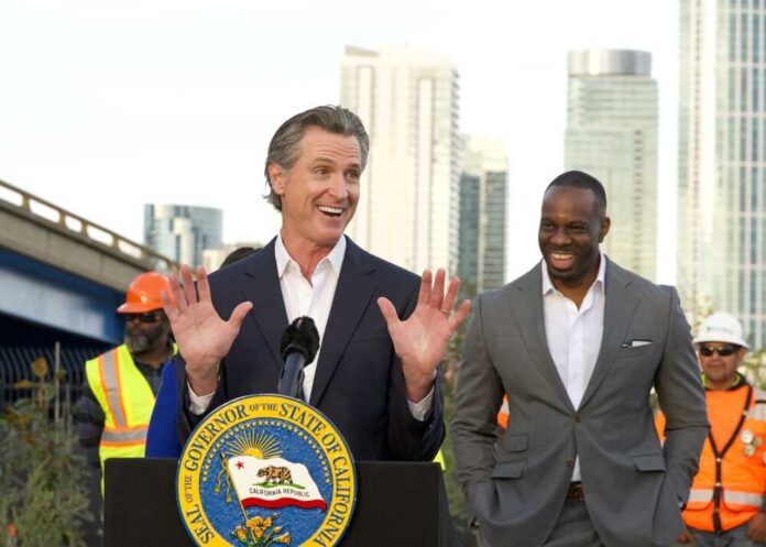 California governor speaking at a construction site with smiling attendees