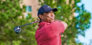 Golfer in a red striped shirt swinging a golf club