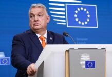 Hungary’s Bold Move Blocks €90 Billion Aid A government official at a podium during a press briefing
