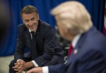 Two political leaders engaged in a conversation, one smiling