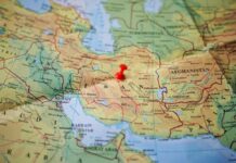 IRAN UNLEASHES Region-Wide Missile Swarm A map of the Middle East with a red pushpin marking a location