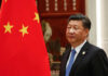 China’s Solar Surge: A Global Power Play Man in suit standing next to Chinese flag
