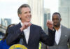 Person speaking at podium with others in background