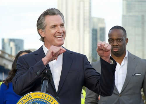Person speaking at podium with others in background