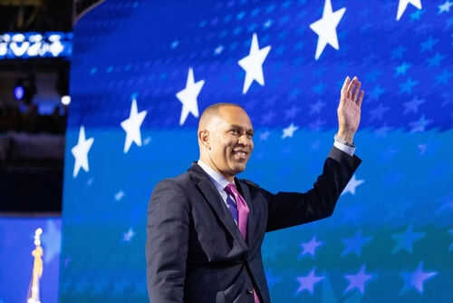 Man in suit waving against starry blue background