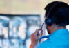 Person with headset monitoring multiple screens