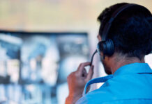 Person with headset monitoring multiple screens