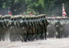 Soldiers in camouflage uniforms marching in formation during a military parade
