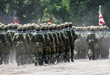 Soldiers in camouflage uniforms marching in formation during a military parade