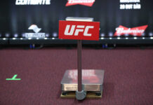 UFC weighing scale with promotional signage in the background