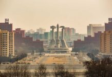 View of a large monument surrounded by buildings in Pyongyang
