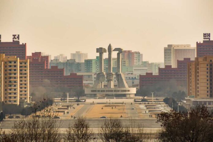 View of a large monument surrounded by buildings in Pyongyang