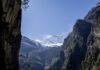 Snow-capped mountains surrounded by rocky cliffs and greenery