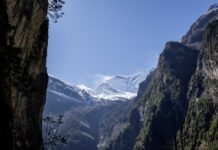 Snow-capped mountains surrounded by rocky cliffs and greenery