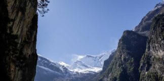 Snow-capped mountains surrounded by rocky cliffs and greenery