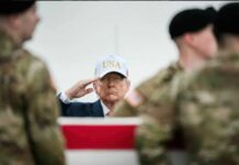 A man in a USA hat saluting during a military ceremony