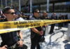 Los Angeles police officers standing behind a police line