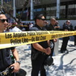 Los Angeles police officers standing behind a police line