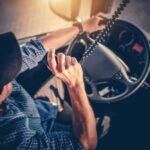 A truck driver using a microphone while driving