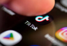 Finger tapping TikTok app on a smartphone screen