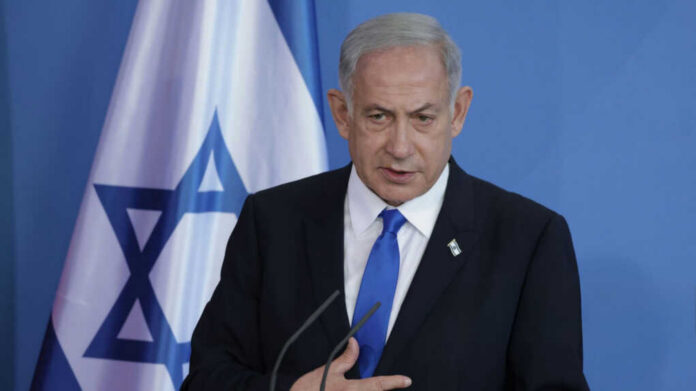 Man speaking in front of Israeli flag backdrop