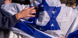 People holding an Israeli flag together, showcasing unity and cultural pride