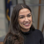 A person smiling, wearing a black shirt.