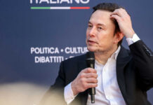 Odyssey Casting Fury: Musk Calls Out Hollywood Man in suit holding microphone at event indoors