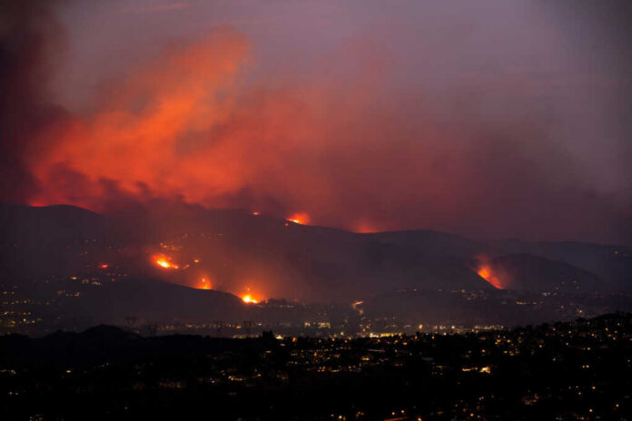 flames-and-smoke1841566390jpg Wildfire glows on hills above a city at dusk