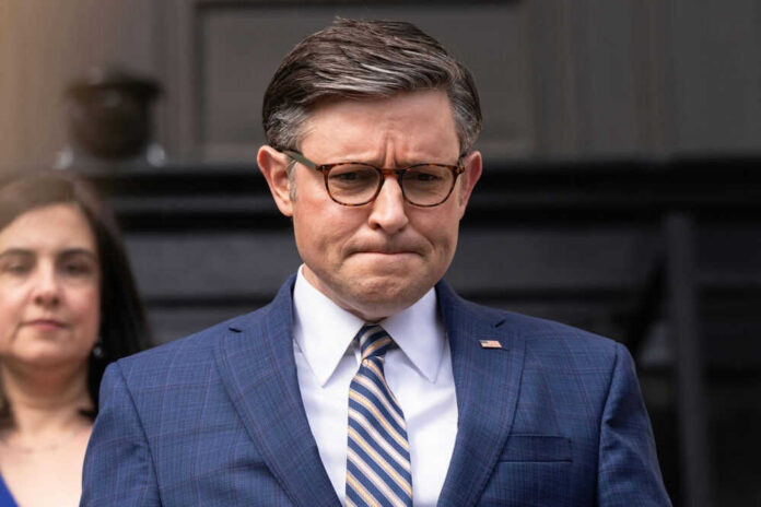 A man in suit and tie, looking serious.