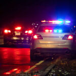 Swatting Hoax Targets Supreme Court Home Police car with flashing lights parked on the roadside at night