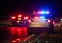 Swatting Hoax Targets Supreme Court Home Police car with flashing lights parked on the roadside at night